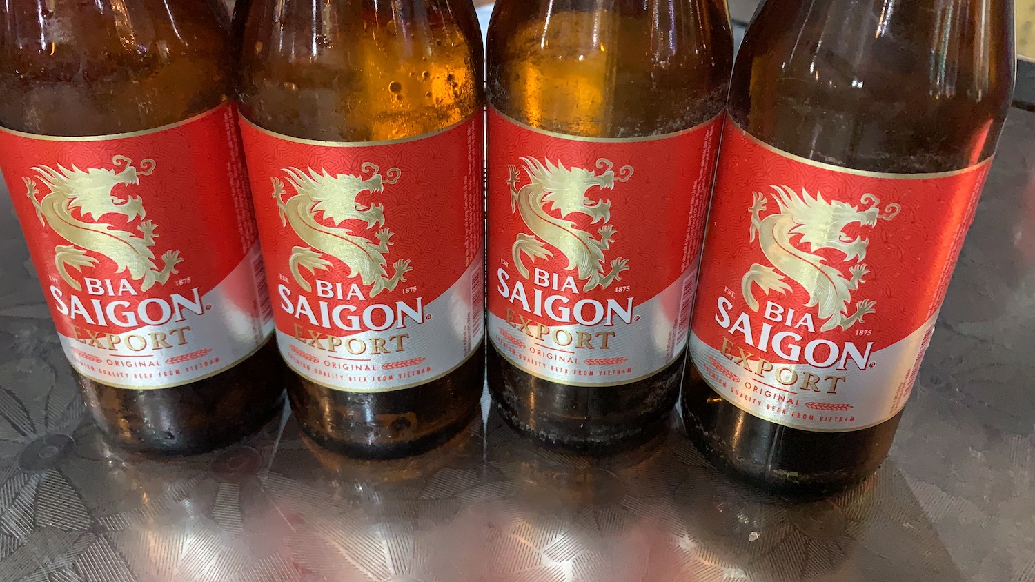 Cuatro botellas de Cerveza Saigon con etiqueta roja